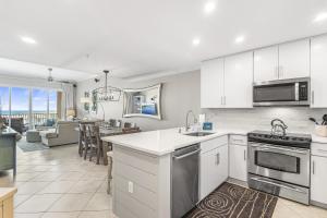 eine Küche mit weißen Schränken und ein Wohnzimmer in der Unterkunft San Remo 403 in Santa Rosa Beach