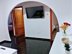 une pièce avec une télévision sur un mur avec une table dans l'établissement Apartamento Campo Rosa Tacoronte, à Tacoronte