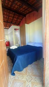 - une chambre avec un lit bleu dans l'établissement chalé mares, à Fortaleza 3 autres photos