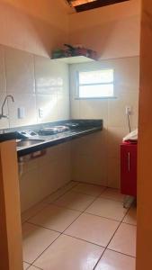 une cuisine avec un comptoir, un évier et une fenêtre dans l'établissement chalé mares, à Fortaleza