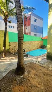 un palmier installé à côté d'une piscine dans l'établissement chalé mares, à Fortaleza