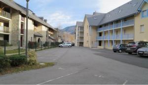 a street in a town with cars parked next to buildings at Appartement Le Courtaou in Vielle-Aure
