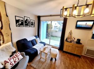 a living room with a couch and a tv at Appartement Le Courtaou in Vielle-Aure