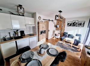 a kitchen and a living room with a table at Appartement Le Courtaou in Vielle-Aure