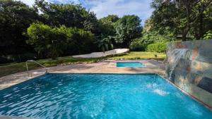 ein großes Schwimmbecken im Hof mit Rutsche in der Unterkunft Casa Pitahaya Marbella with AC, Swimming Pool, Skate Bowl & walking distance Beach for Surfers and Nature Lovers in Marbella