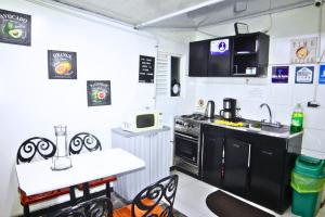 a kitchen with a stove and a sink and a table at Hotel Bogota Home in Bogotá