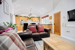 a living room with a couch and a kitchen at Superb Location - 'The Annexe' - at Ty Moel Isaf in Amlwch