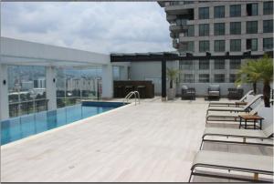 a pool on top of a building with lounge chairs at Hospedaje en Quito Sectro Financiero in Quito