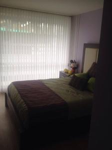 a bedroom with a large bed with a window at Hospedaje en Quito Sectro Financiero in Quito +5 photos