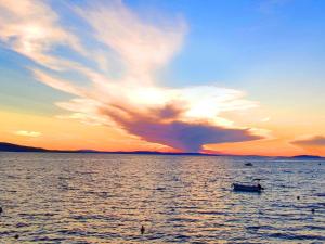 een boot op een grote hoeveelheid water bij zonsondergang bij Sunset Oase Am Meer in Prizna