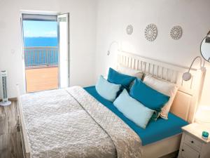 een slaapkamer met een groot bed met blauwe kussens bij Sunset Oase Am Meer in Prizna