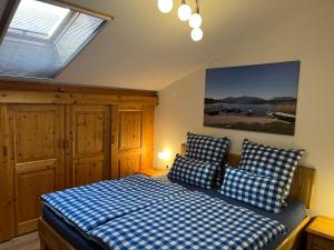 a bedroom with a bed with blue and white checkered pillows at Ferienwohnung Gruberhof 250 m zum Chiemsee Uferweg in Rimsting