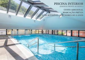 a large swimming pool in a building with windows at Águas do Gerês - Hotel, Termas & Spa in Geres