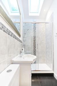 a white bathroom with a sink and a shower at Superb Location - 'The Annexe' - at Ty Moel Isaf in Amlwch