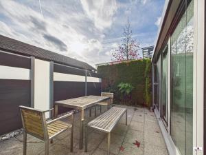 a patio with two benches and a table and chairs at Winter Garden Dream Steinheim in Steinheim an der Murr
