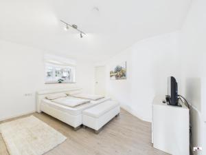 a white living room with a white couch and a tv at Winter Garden Dream Steinheim in Steinheim an der Murr