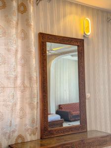 espejo en la pared de una habitación en Hotel Pearl Regency, en Kalām
