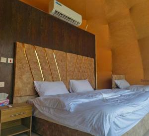 a bedroom with a large bed with a wooden headboard at Wadi Rum Abu Khaled in Wadi Rum