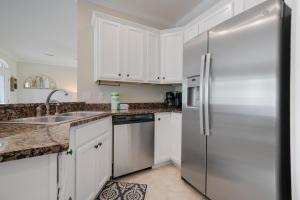 una cucina con mobili bianchi e un frigorifero in acciaio inossidabile di Sandy Bottoms a Santa Rosa Beach
