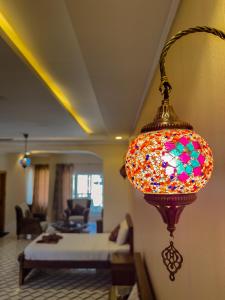 Una luz colorida que cuelga de una pared en una habitación. en Hotel Pearl Regency, en Kalām