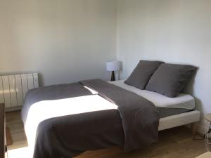 ein Bett mit zwei Kissen darauf in einem Zimmer in der Unterkunft Face à la plage in Rivedoux-Plage
