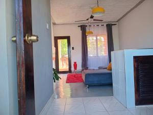 a living room with a blue couch and a bed at Truenorth Apartments siem in Ukunda