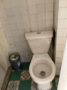 a small bathroom with a white toilet and a trash can at Zona de Camping Hostal Las Hamacas in Villamaría