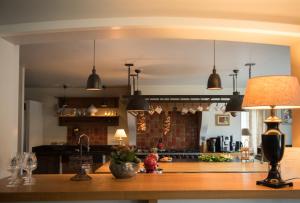 a kitchen with a table with a lamp on a counter at La porte d'Arcy in Fère-en-Tardenois