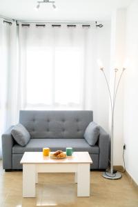 een woonkamer met een bank en een tafel bij Apartamento familiar en Torreblanca con vistas al mar, aire acondicionado y cerca de la playa in Torreblanca