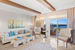 ein Wohnzimmer mit Couch und Stühlen in der Unterkunft Sanctuary by the Sea 3112 by Newman-Dailey in Blue Mountain Beach