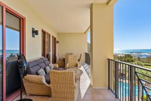 ein Wohnzimmer mit einer Couch und Stühlen auf einem Balkon in der Unterkunft Sanctuary by the Sea 3112 by Newman-Dailey in Blue Mountain Beach + 85 Fotos
