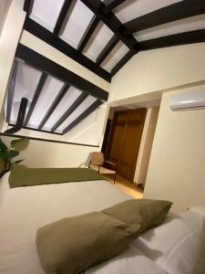 a bedroom with a large white bed with a window at El rincón de Bonilla in El Ronquillo +9 photos