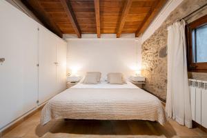 a bedroom with a bed with two pillows on it at El Graner i El Niu in Sant Jaume de Llierca +37 photos