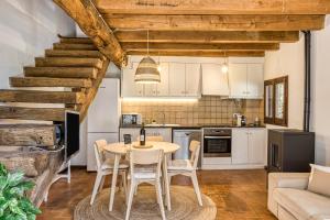 a kitchen and dining room with a table and chairs at El Graner i El Niu in Sant Jaume de Llierca
