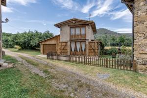 a house with a fence next to a dirt road at El Graner i El Niu in Sant Jaume de Llierca