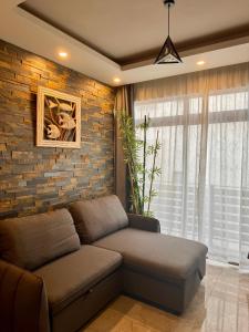 フリック・アン・フラックにあるCoastal Calm The Cove 2のソファとレンガの壁のあるリビングルーム