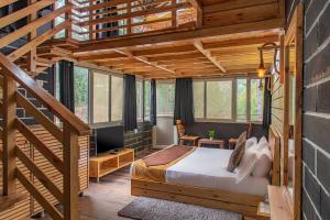 een slaapkamer met een bed en een trap bij The BlackPearl Hillcrest in Kasauli
