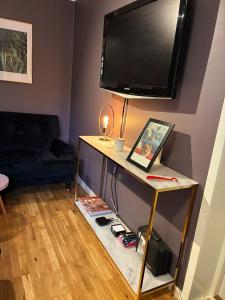 a living room with a table with a television on a wall at Close to Gothenburg & the sea - with your own sauna! in Billdal