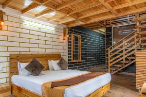 een slaapkamer met een bed en een trap bij The BlackPearl Hillcrest in Kasauli