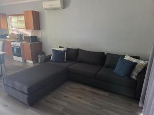 a living room with a couch and a kitchen at Roux Casa in Swellendam