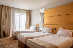 a hotel room with two beds and a window at VIP Executive Azores Hotel in Ponta Delgada +38 photos