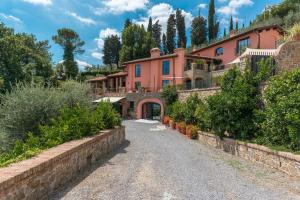 une grande maison rose avec une allée dans l'établissement Villa Le Panteraie con piscina, à Montecatini Alto