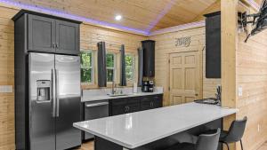 eine Küche mit Edelstahlkühlschrank und Schränken in der Unterkunft True Love Treehouse - Magic Above the Pines in Cleveland