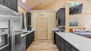 eine Küche mit schwarzen Schränken und ein Bett in einem Zimmer in der Unterkunft True Love Treehouse - Magic Above the Pines in Cleveland