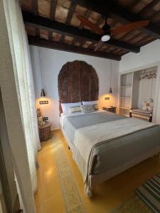 a bedroom with a large bed with a large wooden headboard at Los Ángeles de Sanmartín in Jimena de la Frontera
