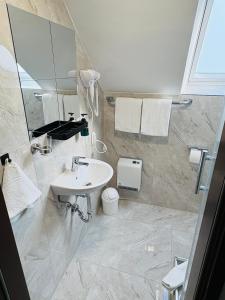 un baño con lavabo y espejo en Hotel Royal, en Leopoldshöhe 61 fotos más