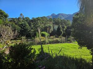 a garden with green grass and mountains in the background at Roux Casa in Swellendam