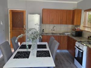 a kitchen with a table with chairs and a white table sidx sidx sidx at Roux Casa in Swellendam