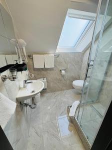 Un baño con ducha, lavabo e inodoro. en Hotel Royal, en Leopoldshöhe