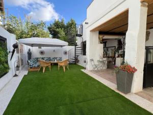 a garden with a table and chairs on a lawn at Los Ángeles de Sanmartín in Jimena de la Frontera